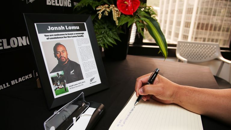 A well-wisher signs a condolence book at New Zealand Rugby Union headquarters following the death of All Blacks legend Jonah Lomu