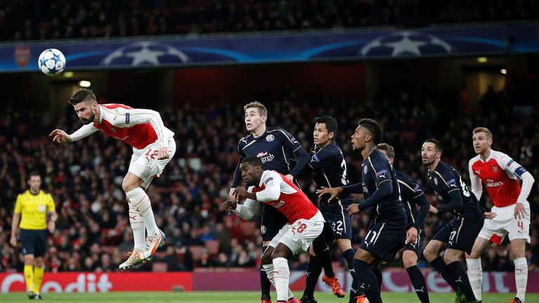 Arsenal's Olivier Giroud (L) heads the ball 