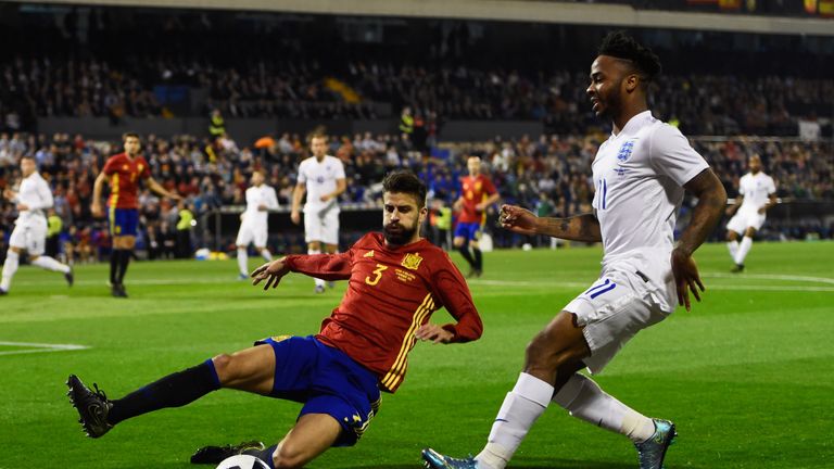 Raheem Sterling of England is faced by Gerard Pique of Spain
