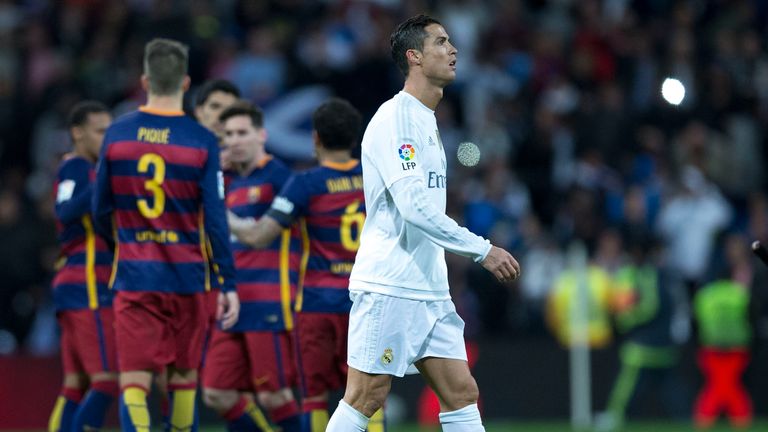 Cristiano Ronaldo of Real Madrid leaves the pitch as Barcelona players celebrate their 4-0 win