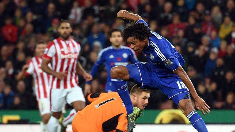 Chelsea's French striker Loic Remy (R) tries to re-gain his balance for a shot after avoiding Stoke City's English goalkeeper Jack Butland