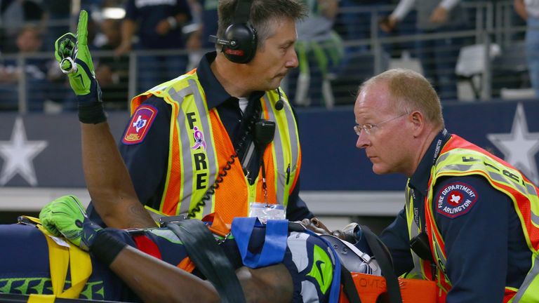 Ricardo Lockette #83 of the Seattle Seahawks waves to fans while being carted off the field in the second quarter at AT&T Stadium