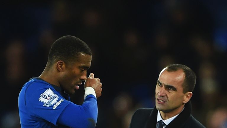 Roberto Martinez manager of Everton speaks to an injured Sylvain Distin