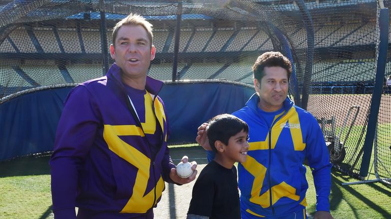 Cricket legends Shane Warne (L) of Australia and Sachin Tendulkar (R) of India stand with young fan Ryan Makhija, 9 at Dodger Stadium