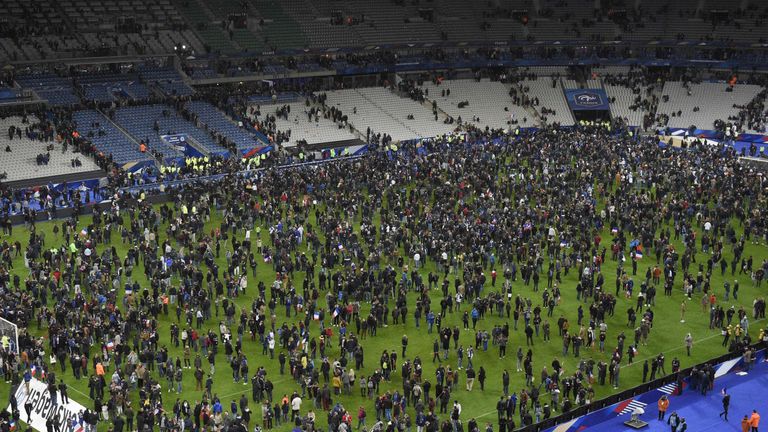 Spectators gather on the pitch of the Stade de France