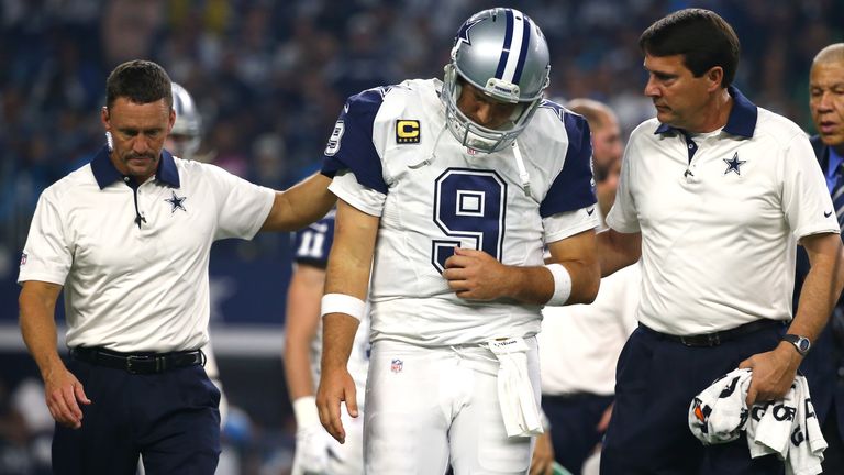 ARLINGTON, TX - NOVEMBER 26: Tony Romo #9 of the Dallas Cowboys is lead to the sidelines by team officials after being sacked by the Carolina Panthers in t