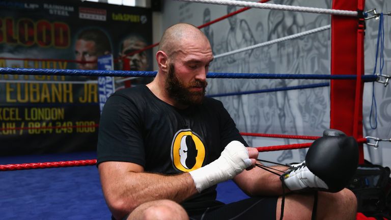 BOLTON, ENGLAND - NOVEMBER 06:  Tyson Fury takes his gloves off during a training session at Team Fury Gym ahead of his fight with Dereck Chisora on Novemb