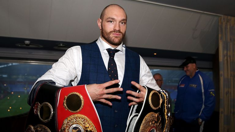 Tyson Fury holds his belts during a homecoming event at the Macron Stadium, Bolton