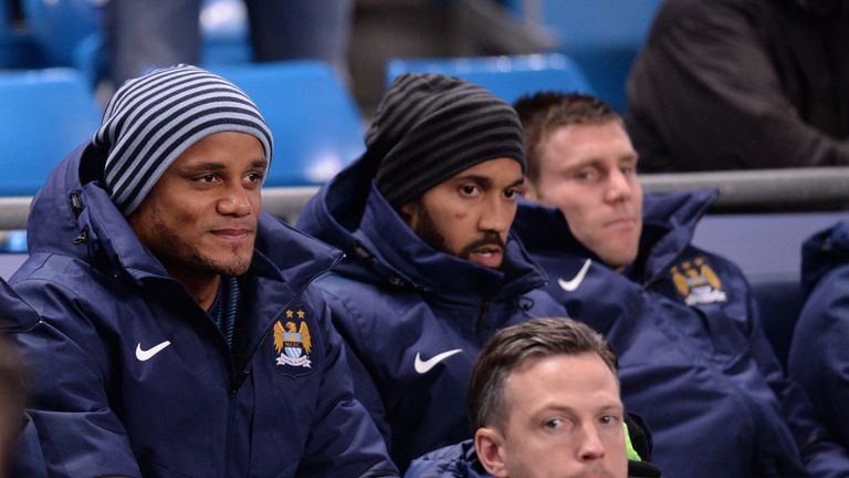 Manchester City's Belgian defender Vincent Kompany (L) looks on from the bench 