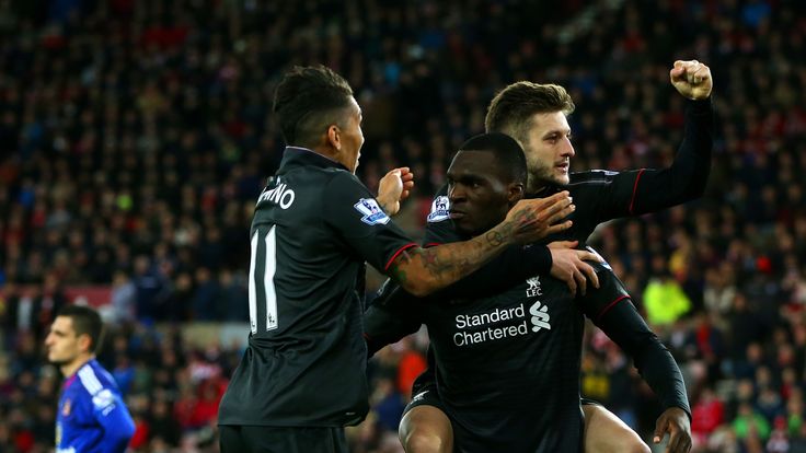 Christian Benteke of Liverpool celebrates with team-mates Adam Lallana and Roberto Firmino as Sunderland's Vito Mannone looks on
