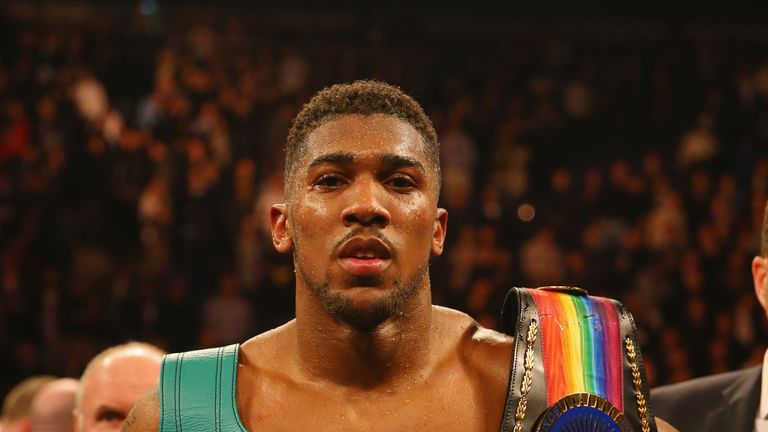 Anthony Joshua celebrates victory over Dillian Whyte with his belts after the British and Commonwealth heavyweight title contest