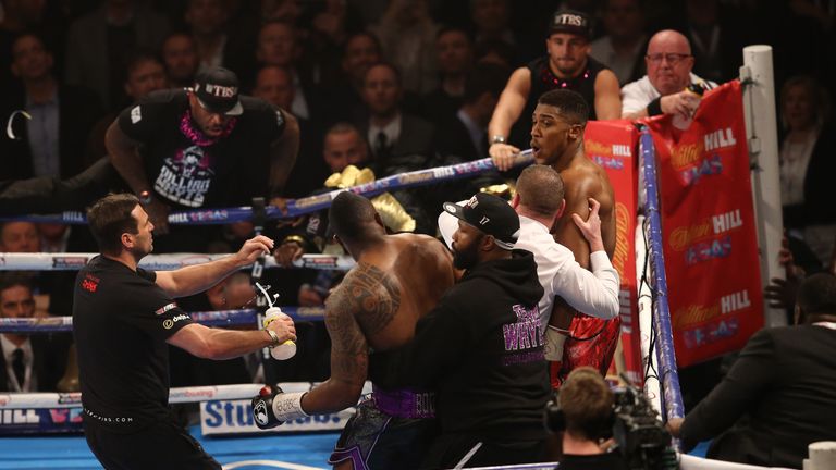 Referee Howard Foster (C white shirt) tries to separate British boxer Dillian Whyte (2L) and British boxer Anthony Joshua (R)