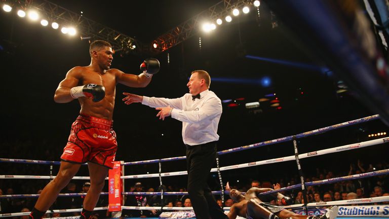 LONDON, ENGLAND - DECEMBER 12:  Anthony Joshua (L) reacts as he knocks Dillian Whyte (R) down in the seventh round during the British and Commonwealth heav