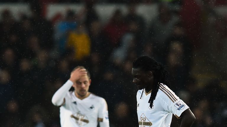  Swansea striker Bafeimbi Gomis prepares to restart after the third goal as Gylfi Sigurdsson (c) reacts