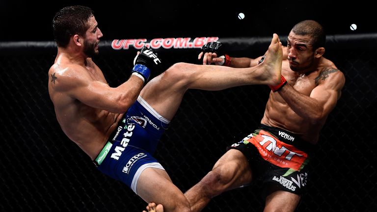 Chad Mendes of the United States kicks Jose Aldo of Brazil in their featherweight championship bout during the UFC 179