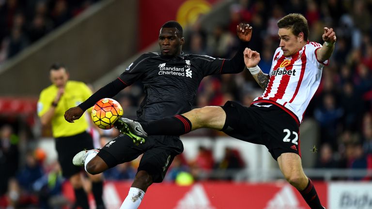 Christian Benteke of Liverpool attempts to shoot at goal under pressure from Sebastian Coates of Sunderland