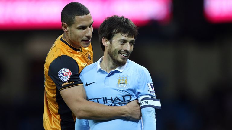 Hull City's captain Jake Livermore hugs Manchester City's David Silva