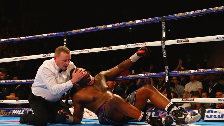 LONDON, ENGLAND - DECEMBER 12:  the referee assists Dillian Whyte as he clings to the ropes after being knocked down by Anthony Joshua in the seventh round