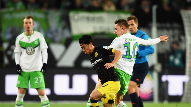 Shinji Kagawa of Dortmund is challenged by Julian Draxler of Wolfsburg during the Bundesliga match between VfL Wolfsburg and Borussia Dortmund