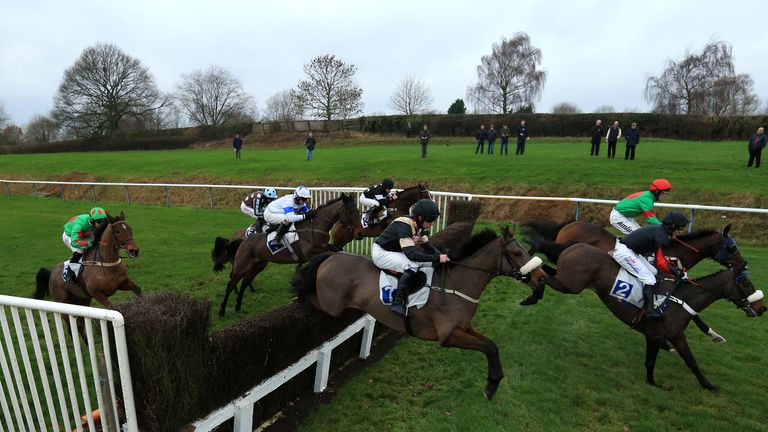 Court Dismissed takes the runners over the first fence in the Lubenham Novices' Limited Handicap Chase at Leicester Racecourse.