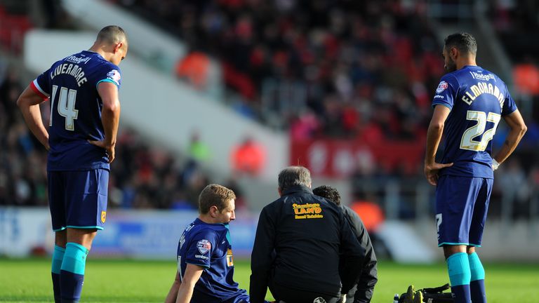 Michael Dawson of Hull City (C) receives treatment after suffering an injury