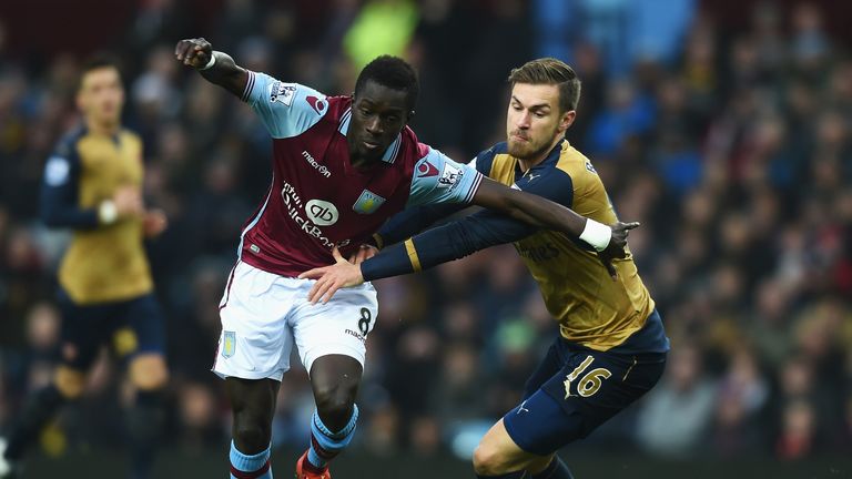Idrissa Gueye of Aston Villa holds off Arsenal's Aaron Ramsey