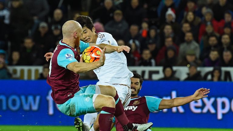 James Collins of West Ham appears to handle the shot from Ki Sung-Yeung of Swansea City