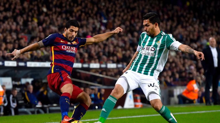 Luis Suarez of FC Barcelona competes for the ball with Juan Vargas of Real Betis