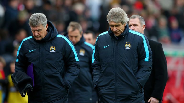 Manuel Pellegrini (R), manager of Manchester City and coach Brian Kidd (L) leave the pitch at the half time during the match against Stoke City