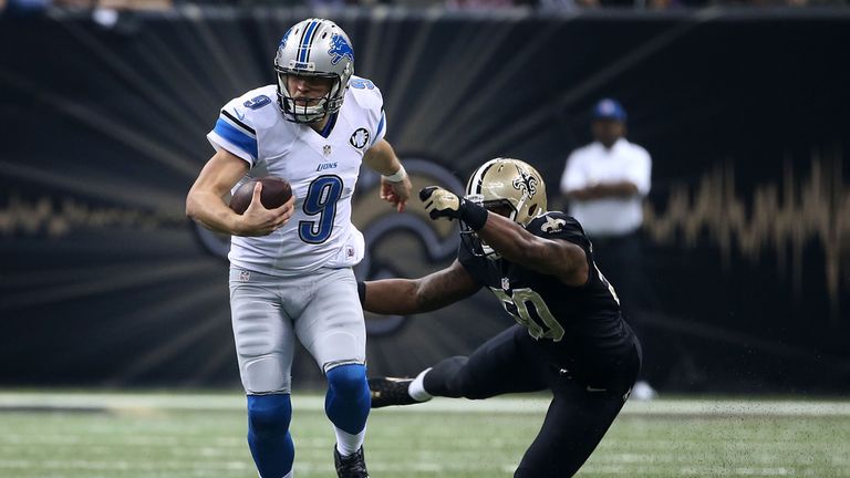 Matthew Stafford #9 of the Detroit Lions avoids a tackle by Stephone Anthony #50 of the New Orleans Saints