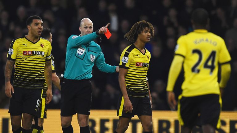 Nathan Ake (R) of Watford is shown a red card by referee Anthony Taylor (L) during the match against Tottenham Hotspur