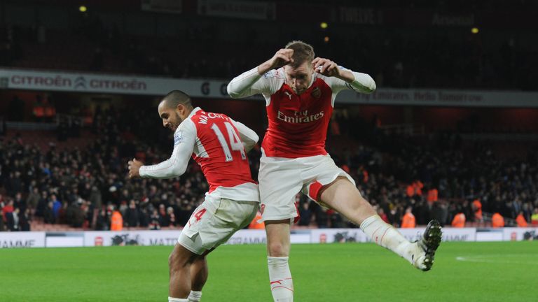 Per Mertesacker (R) and Theo Walcott celebrate Arsenal's win over Manchester City