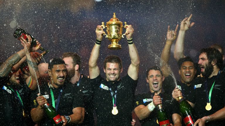 LONDON, ENGLAND - OCTOBER 31:  Richie McCaw of New Zealand lifts the Webb Ellis Cup as his team-mates spray champagne after victory in the 2015 Rugby World