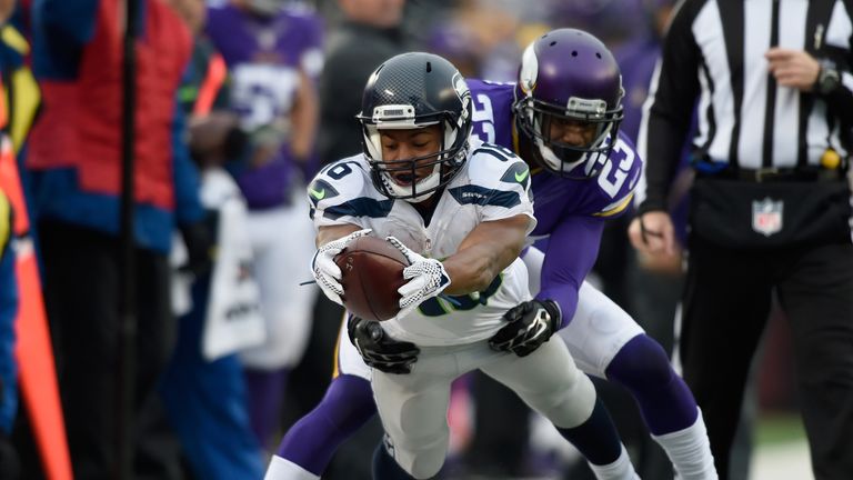 Tyler Lockett #16 of the Seattle Seahawks reaches for a first down as Terence Newman #23 of the Minnesota Vikings forces him 