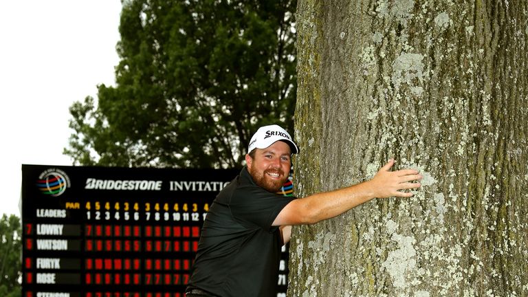 AKRON, OH - AUGUST 09: Shane Lowry of Ireland hugs a tree near the 18th green with the Gary Player Cup after winning the World Golf Championships - Bridges
