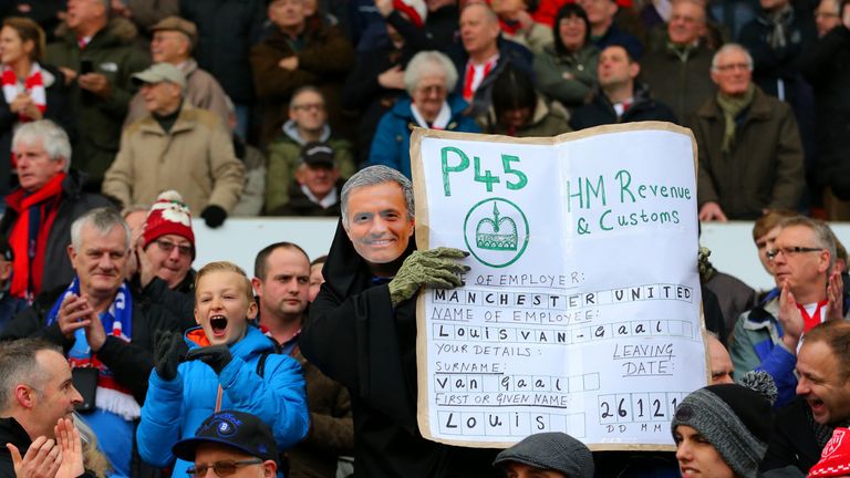 A Stoke City fan wears a Jose Mourinho mask as he poses with a P45 for Manchester United manager Louis van Gaal 