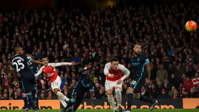 Theo Walcott of Arsenal puts Arsenal 1-0 up against Manchester City