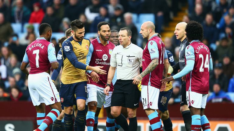 Aston Villa players protest to referee Kevin Friend