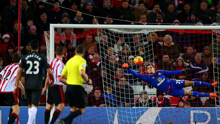 Vito Mannone dives as he stretches to save a shot from Roberto Firmino