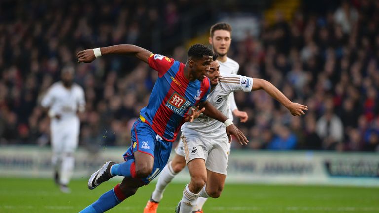Crystal Palace striker Wilfried Zaha (L) and Swansea City's Neil Taylor (R) chase the ball