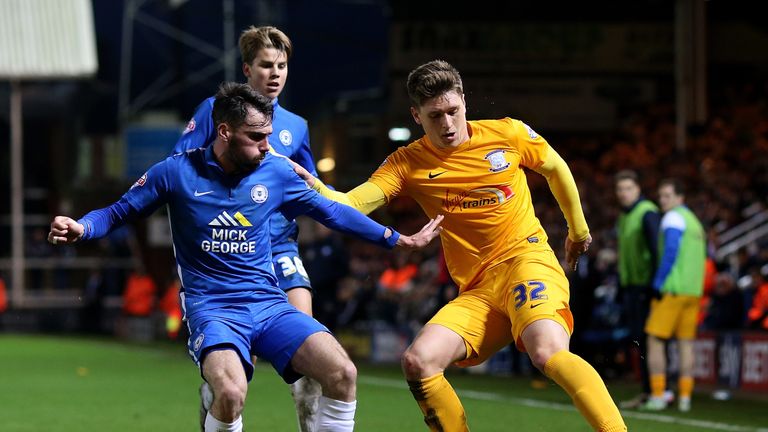 Adam Reach of Preston holds off pressure from Peterborough's Michael Smith