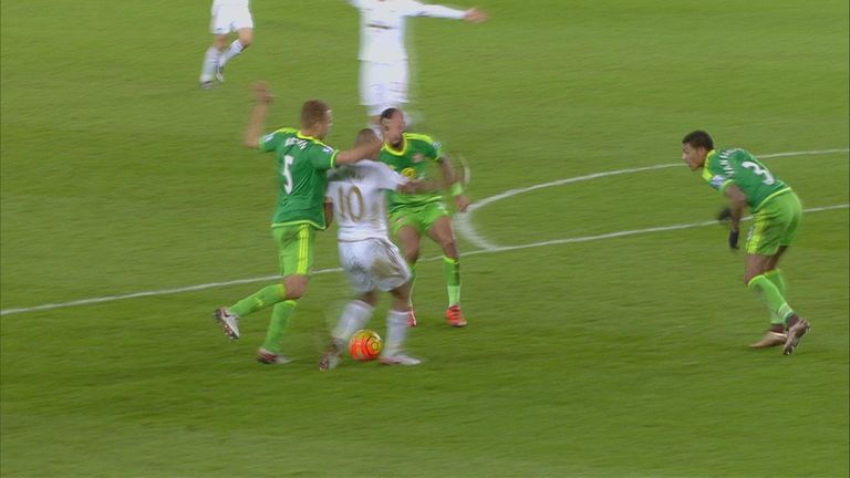 Andre Ayew falls with Wes Brown behind him but kicks the ground with his left foot