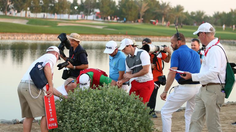 McIlroy helps Andy Sullivan search for his ball at the ninth, but it could not be found