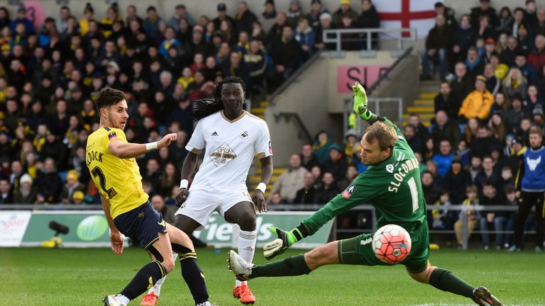 OXFORD, ENGLAND - JANUARY 10:  Bafetimbi Gomis of Swansea City shoots past goalkeeper Sam Slocombe of Oxford United to score his team's second goal during 