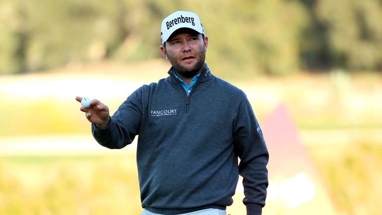 Branden Grace of South Africa waves to the crowd after putting on the 18th during the third round of the Commercial Bank Qatar Masters.