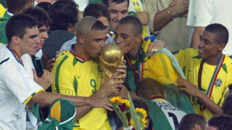 Brazil's forward Ronaldo (C) and midfielder Gilberto Silva (2nd R) kiss the World Cup trophy
