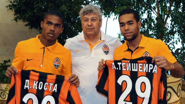 FC Shakhtar head coach Romanian Mircea Lucescu  (C) presents  new players of the team, Brazilian midfielder Douglas Costa  (L) and Alex Teixeira