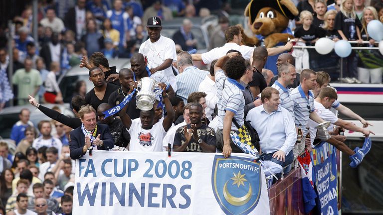 Harry Redknapp (L) and Ghanaian player Sulley Muntari (with the cup) and the rest of the Portsmouth football team parade the FA Cup thro