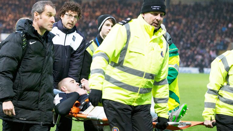 Dundee defender James McPake is carried off after suffering a suspected knee injury