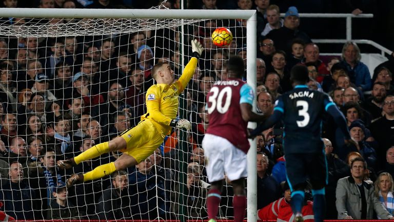 Manchester City goalkeeper Joe Hart (L) saves a shot